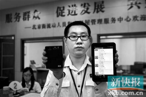 　越秀區(qū)北京街出租屋外來(lái)暫住人員管理服務(wù)中心的工作人員展示到出租屋登記來(lái)穗人員信息的儀器。