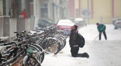 小伙子跪在樓前，一直抬頭看著樓上。 孫立國/攝