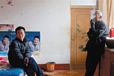 父親抽煙，兒子不語。逃跑的越南新娘，給袁迎賓父子帶來的是失落。新京報記者