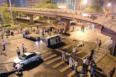 路虎沖下國貿(mào)橋砸中一輛起亞轎車，橋上厚達幾十厘米的水泥護欄被撞斷，碎石四處散落，數(shù)十群眾在現(xiàn)場圍觀。