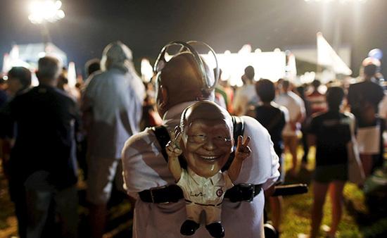 9月4日，新加坡，執(zhí)政黨的一場集會上，一名支持者背著一個李光耀的人偶。