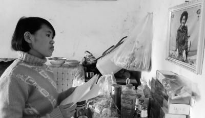 錢仁鳳站在母親遺像前。未能見母親最后一面是她的一大遺憾。