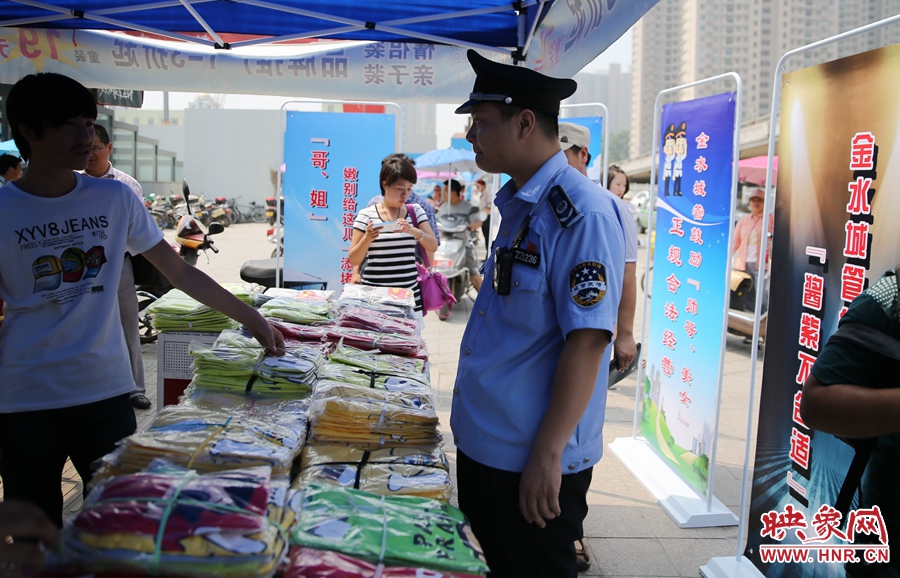 執(zhí)法人員勸導(dǎo)看守?cái)偽坏娜藛T搬離，停止非法占道經(jīng)營(yíng)。