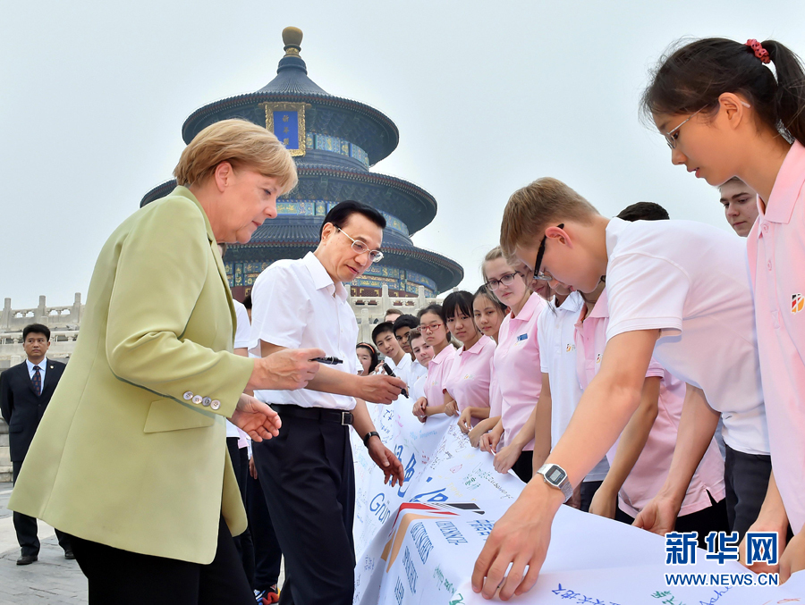 李克強同默克爾在紀念橫幅上簽名。