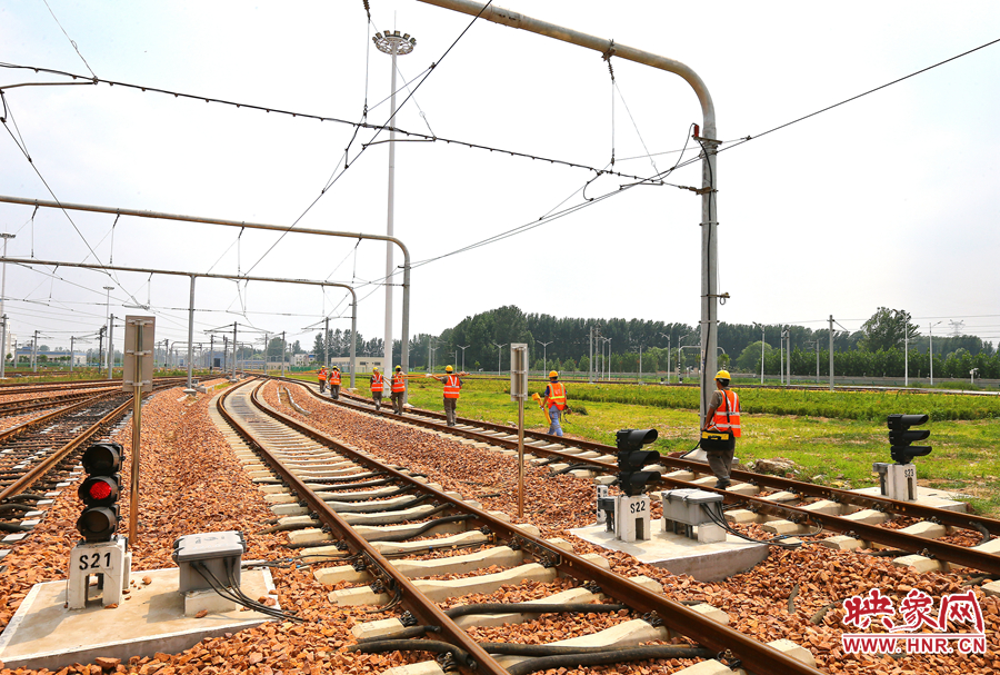 在太陽(yáng)的直射下，檢修工人扛著沉重的設(shè)備向施工地點(diǎn)出發(fā)