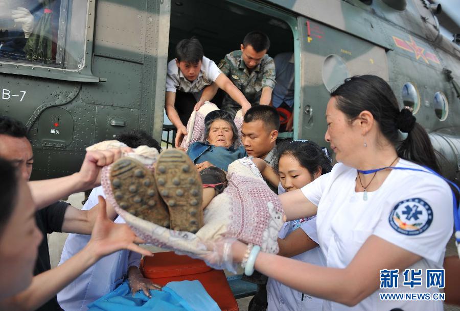 8月5日，醫(yī)護(hù)人員將一名通過直升機(jī)從震中轉(zhuǎn)運(yùn)出來的傷員運(yùn)下飛機(jī)。
