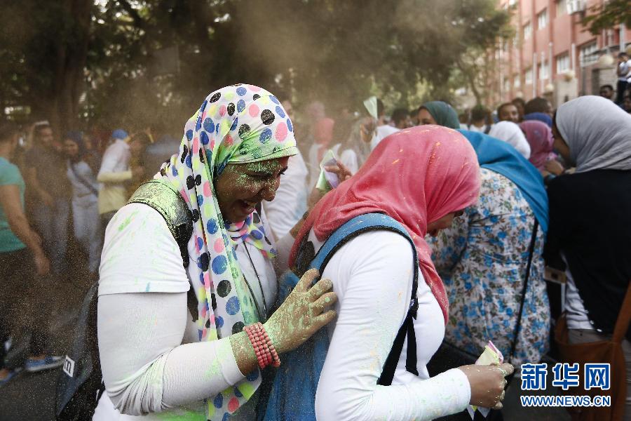 10月16日，在埃及首都開羅，兩名女青年在“彩色跑”活動中躲避人們拋撒的彩色粉末。