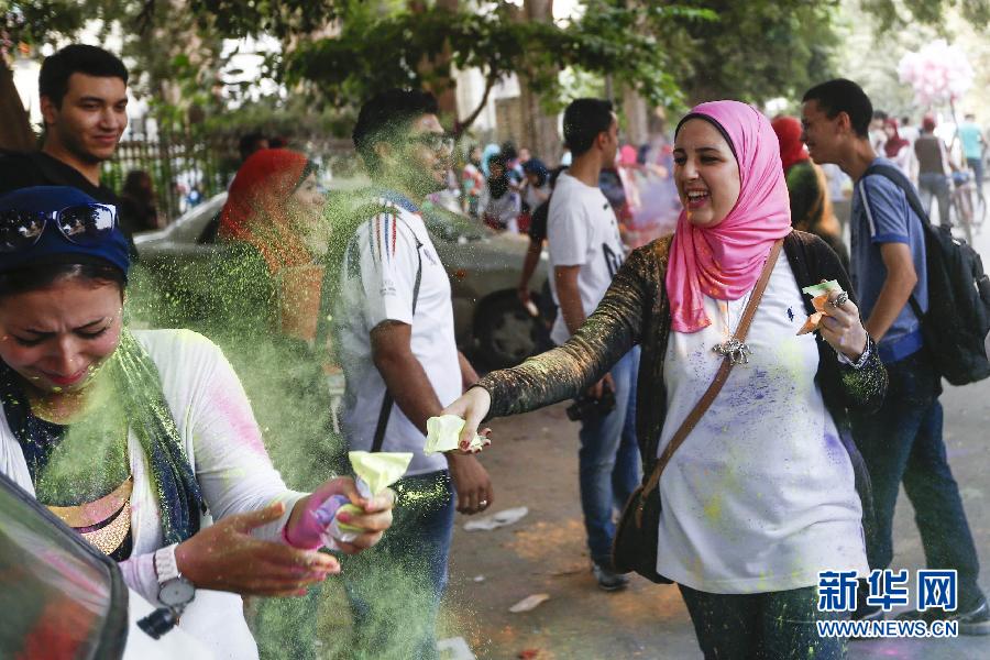 10月16日，在埃及首都開羅，一名女青年在“彩色跑”活動中拋撒彩色粉末。