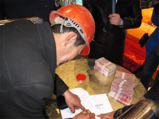 農(nóng)民工在現(xiàn)場領(lǐng)取工資。