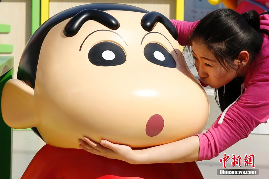 4月22日，游客與蠟筆小新合影。“蠟筆小新25周年紀(jì)念特展”日前在北京開(kāi)展，吸引了不少市民游客。