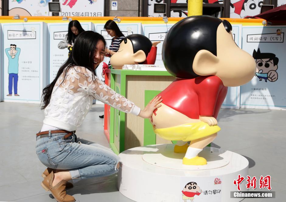 4月22日，游客與蠟筆小新合影?！跋灩P小新25周年紀(jì)念特展”日前在北京開(kāi)展，吸引了不少市民游客。