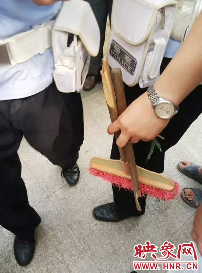 老太從環(huán)衛(wèi)工手中奪過掃帚，用腳踩斷，用力向環(huán)衛(wèi)工人的手上和腿上敲去。