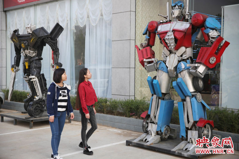 10月14日，市民在參觀河南省平頂山市寶豐縣一家企業(yè)門前的“變形金剛”。