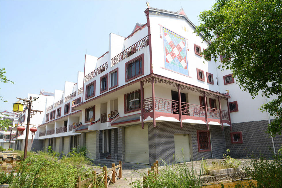 2016年7月26日，村民在廣西來賓市忻城縣隆達(dá)山水福城荒廢別墅間放牛。