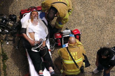 2日，救援人員在美國紐約地鐵事故車輛內(nèi)緊急疏散一名受傷乘客。圖/CFP