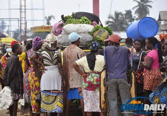 當?shù)貢r間2014年8月14日，利比里亞蒙羅維亞，市場里的商人們圍著一輛汽車。