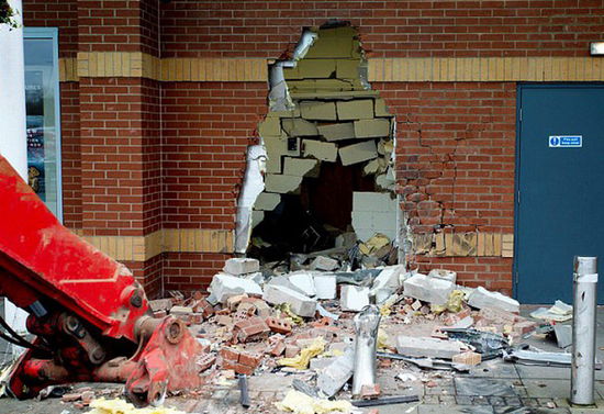 劫匪利用挖掘機(jī)的機(jī)械臂移走ATM機(jī)，留下滿地狼藉