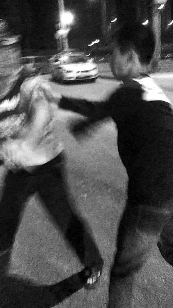 一名男子扯著民警的反光背心一路追打。