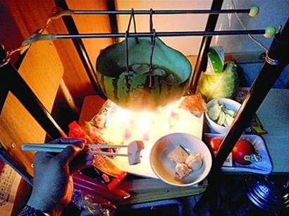 兩張椅子被面對(duì)面疊在一起，穿了兩根線的西瓜皮就懸空在椅腳中間，下面有蠟燭加熱，這就是西瓜火鍋。