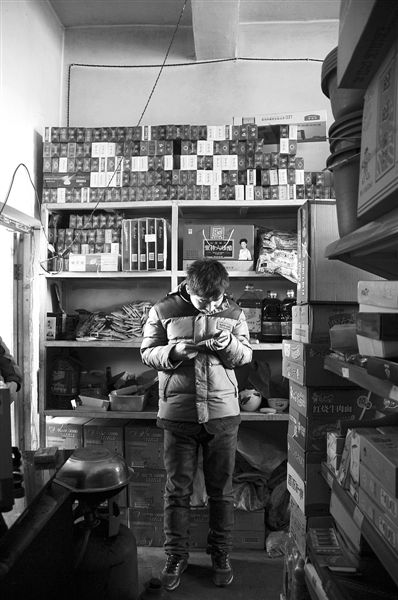 1月21日，周瑋在自家的超市里玩計算器。