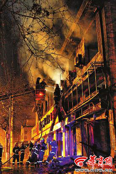 昨日22時(shí)10分，西安市豐慶路南小巷南口，消防官兵架梯子登上二樓施救 本組圖片由本報(bào)記者 閆文青 攝