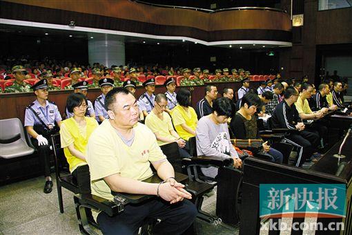 ■蔣洪偉(左一)等二十幾名被告被指控犯集資詐騙罪,昨日集體過(guò)堂?！　?鄭朝暉/攝