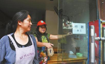 8月14日，市民志愿者體驗城管執(zhí)法招呼商家不要亂張貼。