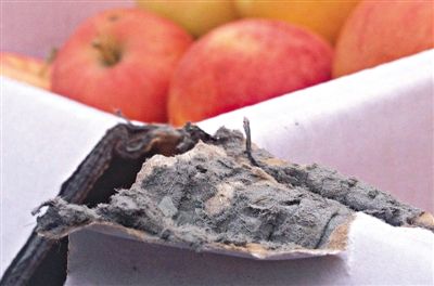 8月29日，新發(fā)地市場(chǎng)，一箱用“加重紙箱”包裝的蘋(píng)果正待售，紙箱夾層內(nèi)灰黑色的增重填充物清晰可見(jiàn)