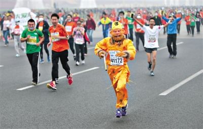 長(zhǎng)安街，一名打扮成孫悟空的參賽者在北馬隊(duì)伍里飛奔。 本版攝影/新京報(bào)記者 吳江 李飛 王嘉寧 吳江