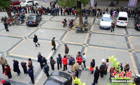 圖為10月28日，在江西九江市一家羊絨皮草服裝服飾博覽會現(xiàn)場，老人們正在頂著寒風(fēng)排隊(duì)等待領(lǐng)取10元代金劵。