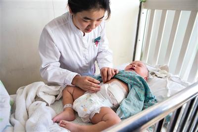 昨日，北京兒童醫(yī)院，護(hù)士為即將出院的被扎鋼針女嬰檢查傷口恢復(fù)情況。記者 高瑋 攝