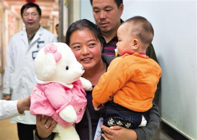 昨日上午，被扎針女嬰的母親抱著孩子和醫(yī)護(hù)人員送的玩偶準(zhǔn)備出院，院方稱孩子術(shù)后恢復(fù)良好。記者 高瑋 攝