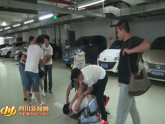 辦案人員在機(jī)場(chǎng)停車場(chǎng)抓獲胡某及其女友（警方視頻截圖）。