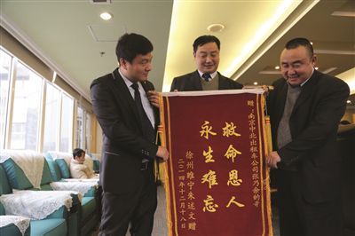 張乃余(中)和兩位救人的同伴一塊領(lǐng)獎。