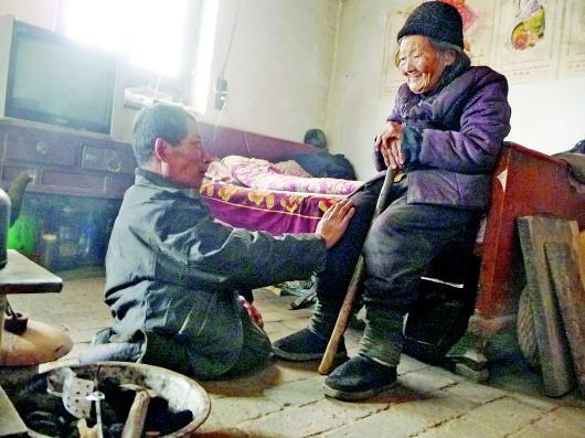 52歲的劉蘭山每天靠爬行照顧90歲的老母親。孫國祥 攝