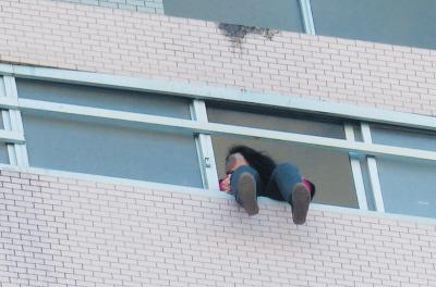 28樓的窗臺(tái)上坐著一名女子，其兩條腿耷拉在室外，不停地?cái)[動(dòng)。