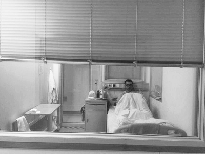 楊杰在醫(yī)院隔離病房中，沖記者揮了揮手。