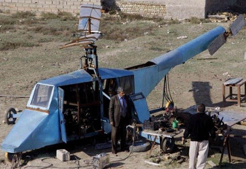 哈蒂姆·卡迪姆·薩爾曼正與工人交談，背后就是他正在制造的直升機(jī)