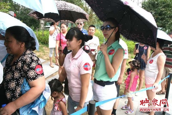 佩戴信息廣播臂貼的聽眾們在排隊(duì)等候坐帆船。