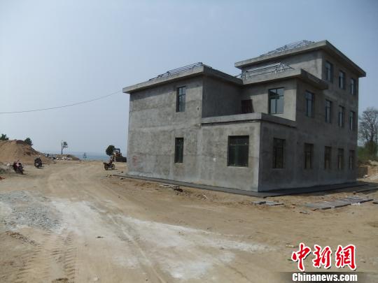 鴨河水庫(kù)庫(kù)區(qū)邊的新建別墅，一面墻上寫著“拆”，另一邊在加緊施工。吳揚(yáng)　攝